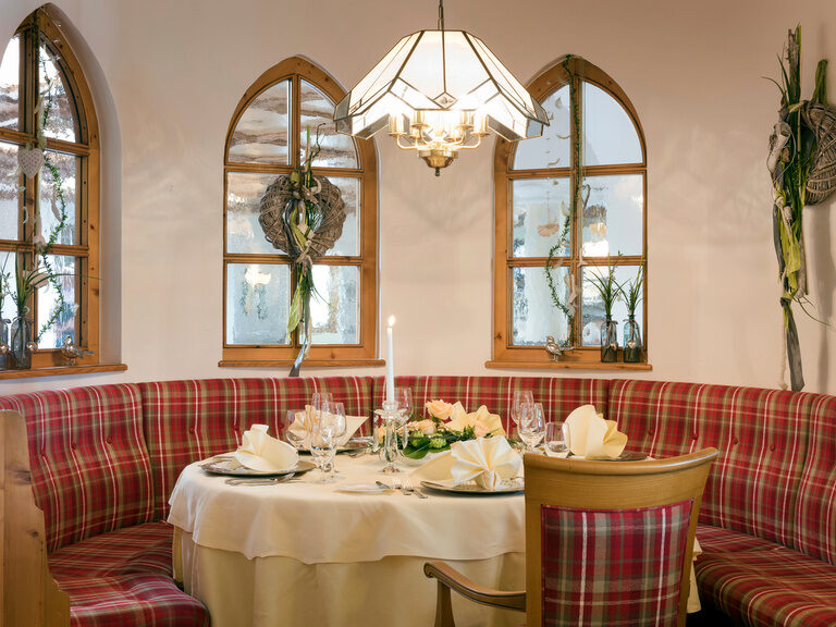 Schlichtes Speisezimmer in der Antoniusstube des Restaurants im Hotel Mooshof im Bayerischen Wald mit Tisch und Fenstern.
