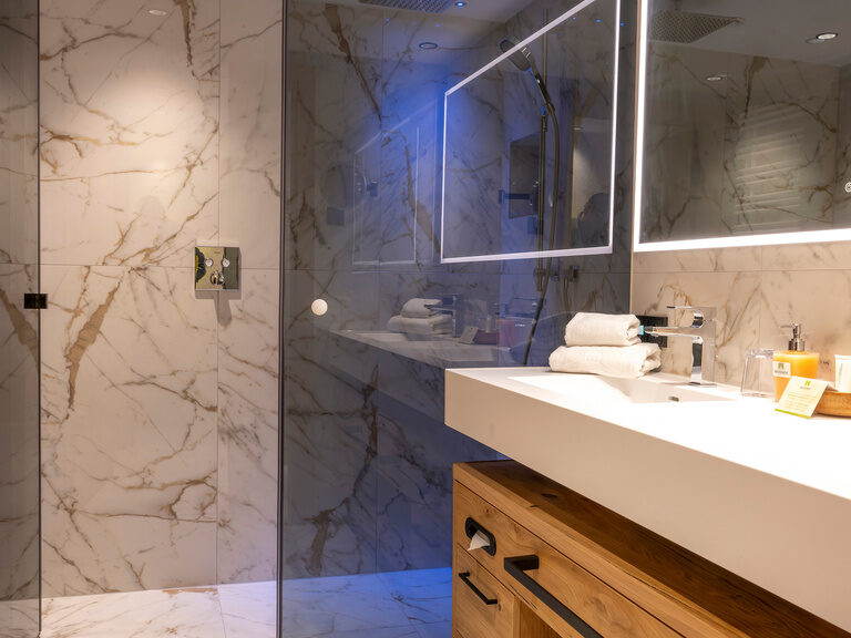 Modernes Badezimmer-Design mit Waschbecken und Spiegel in Zimmer Typ 3 des Wellnesshotels Mooshof im Bayerischen Wald.