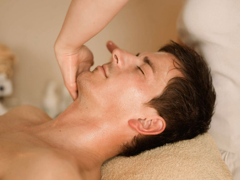 Ein Mann mit geschlossenen Augen genießt die Ruhe bei einer Gesichtsmassage im Wellnesshotel Mooshof im Bayerischen Wald.