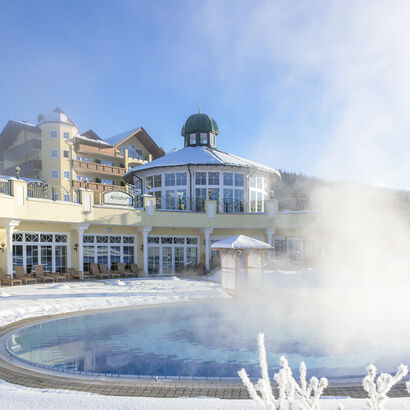 Der dampfende Aussenpool im verschneiten Wellnessbereich vom Hotel Mooshof im Bayerischen Wald.