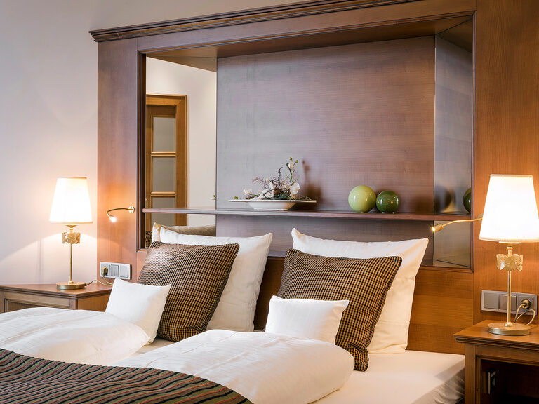 Gemütliche Schlafstätte in der Wellnesssuite Bergzauber des Wellnesshotels Mooshof im Bayerischen Wald mit schicker Beleuchtung.