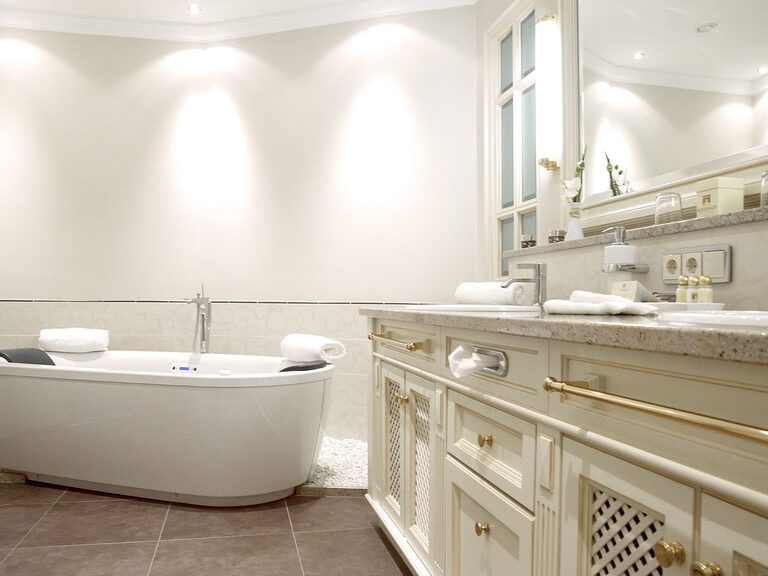 Das Badezimmer der Berkhain Suite Deluxe im Wellnesshotel Mooshof im Bayerischen Wald zeigt ein modernes Waschbecken und eine große Design-Badewanne.