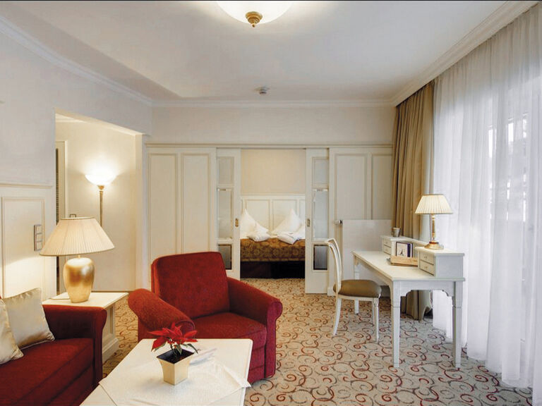 Einladender Wohnraum mit hellem Interieur und gemütlichen Sitzgelegenheiten in der Birkenhain-Suite des Wellnesshotels Mooshof in Bodenmais.