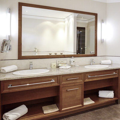 Zwei Waschbecken und ein großer Spiegel im Bad der Turmsuite Hochzell des Wellnesshotels Mooshof in Bayern.