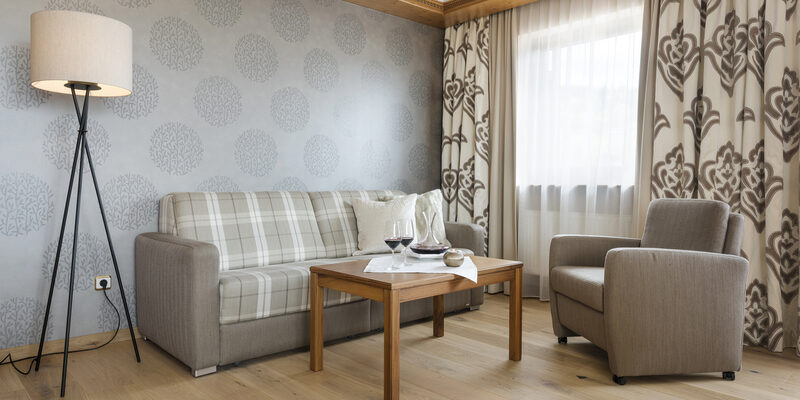 Ein elegant möblierter Wohnbereich in der Panoramasuite mit einer modernen Stehlampe und einem bequemen Sessel.