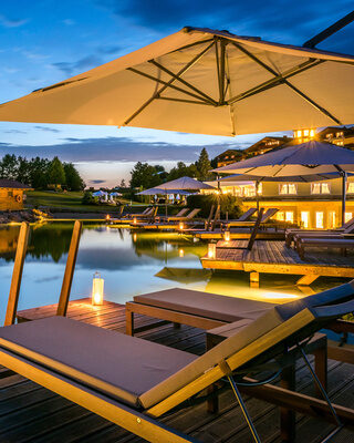 Ein romantisches Badeerlebnis beim Naturbadesee bei Sonnenuntergang im Wellness-Hotel Mooshof.