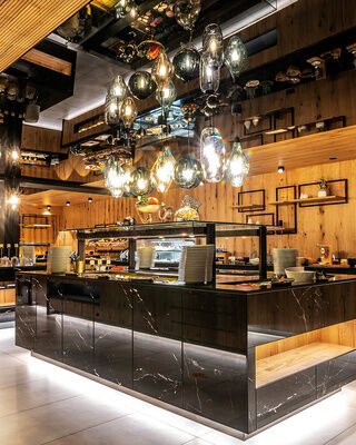 Die große moderne Buffet Theke des Restaurants im Wellnesshotel Mooshof in Bodenmais mit köstlichen verschiedenen Speisen zur Auswahl.