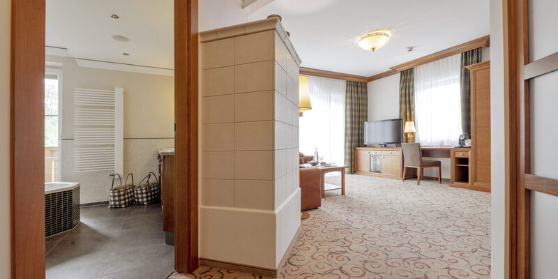 Die hochwertige Einrichtung mit modernen Badezimmer und Fernseher in der Turmsuite Hochzell des Wellnesshotels Mooshof in Bayern spiegelt erstklassiges Design wider.