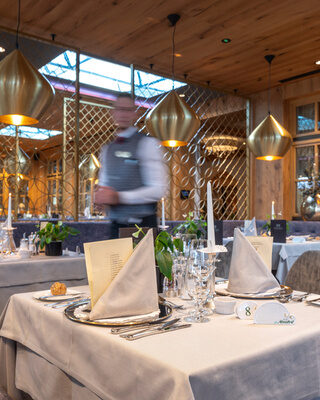 Ein eleganter Tisch mit weißem Tischtuch im Restaurant Mooshof.