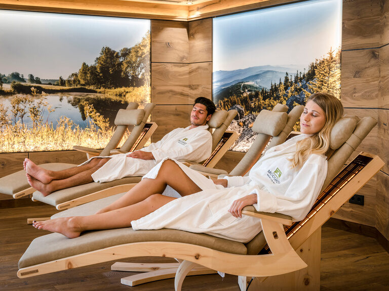 Ein Wellness & SPA Resort Mooshof-Gästepaar in entspannter Atmosphäre auf einer Liege im gemütlichen Ruheraum.