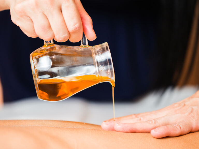 Ölbehandlung für den Rücken einer Frau in dem Wellnessbereich des Wellnesshotels Mooshof im Bayerischen Wald.