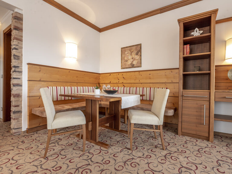 Geschmackvoll gestaltete Erkersuite Deluxe mit gemütlicher Eckbank im Wellnesshotel Mooshof im Bayerischen Wald.