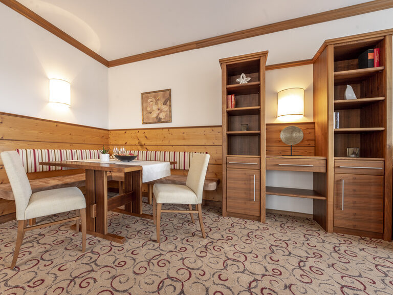 Die Erkersuite Deluxe mit gemütlicher Sitzbank und großen Bücherregalen im Wellnesshotel Mooshof in Bodenmais.