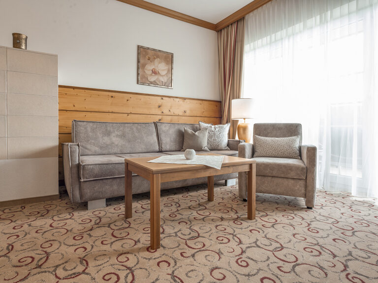 Im Wohnzimmer der Erkersuite des Hotels Mooshof im Bayerischen Wald laden zwei Sofas und ein Couchtisch zum Verweilen ein.