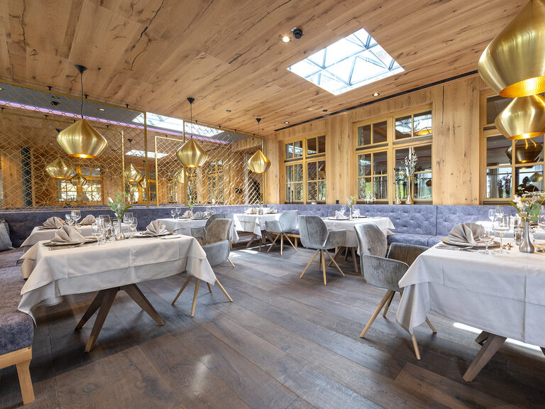 Elegante Tisch- und Stuhlarrangements für die Gäste im 4-Sterne-Restaurant des Wellnesshotels Mooshof im Bayerischen Wald.