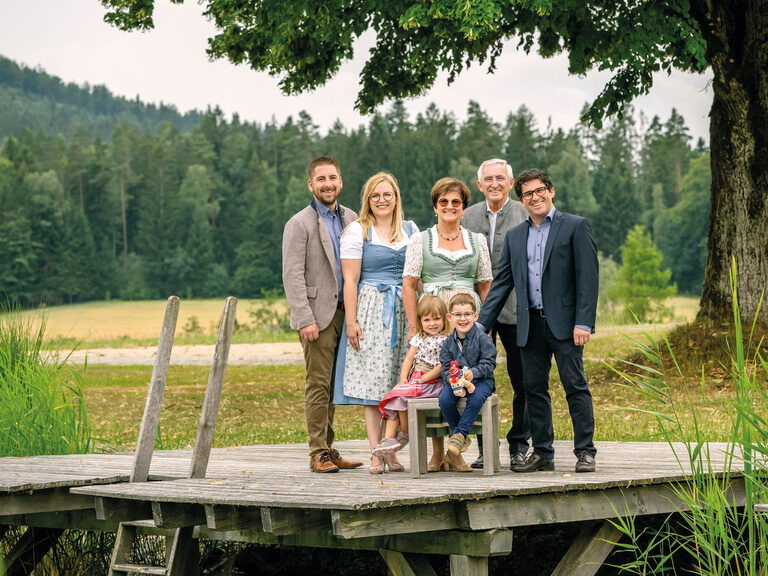 Die Familie Holzer, Leiter des Welllnesshotels Mooshof im Bayerischen Wald steht auf einer Brücke des Naturbadesees.