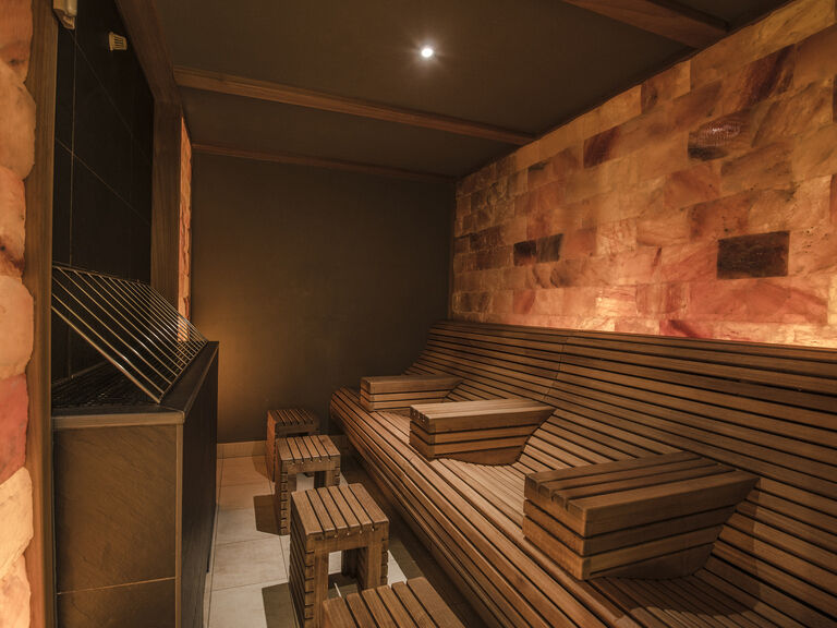 Holzbänke in der finnischen Sauna des Wellnesshotels Mooshof in Bayern schaffen eine rustikale Atmosphäre.