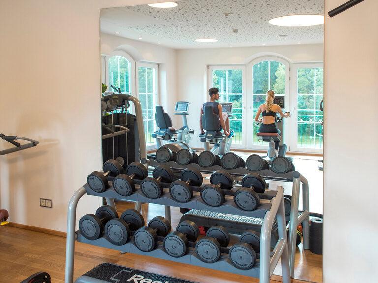 Der moderne Fitnessraum, ausgerüstet für umfangreiches Krafttraining mit Hanteln im Hotel Mooshof in Bayern.