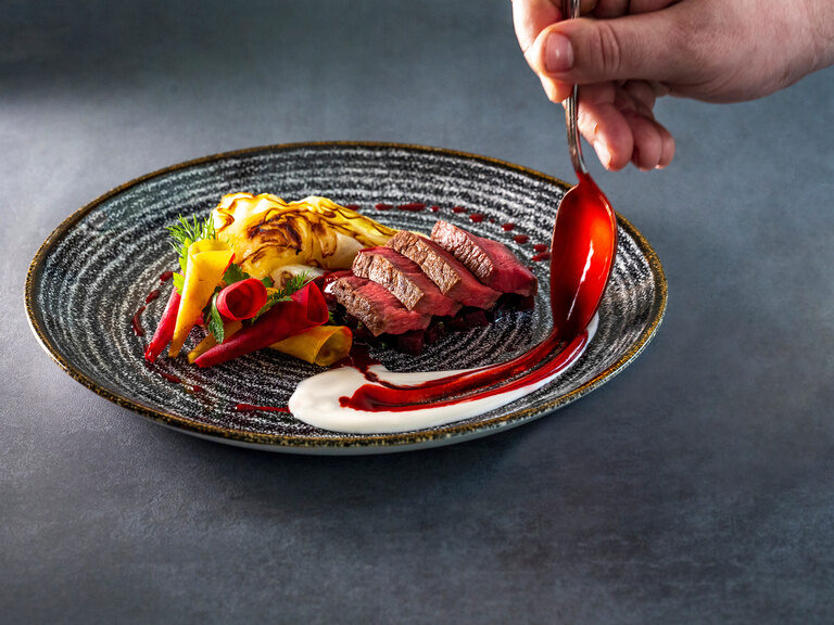 Ein köstliches Fleischgericht auf einem Teller im 4-Sterne-Wellnesshotel Mooshof im Bayerischen Wald.