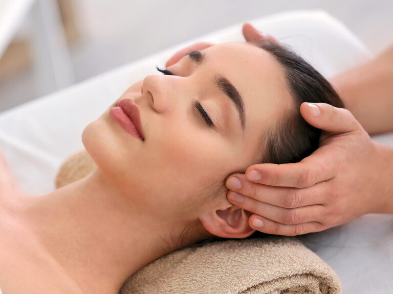 Eine Frau erhält eine wohltuende Gesichtsmassage zur Hautpflege und Entspannung im Spa.
