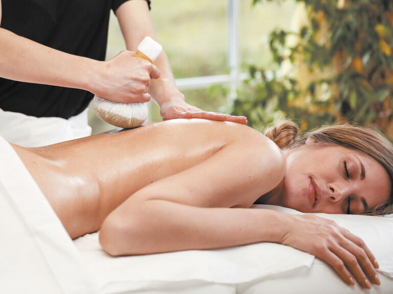 Eine erholsame Rücken Massage mit Kräuterwickel im Wellnesshotel Mooshof im Bayerischen Wald zur Stressreduktion.