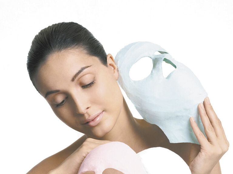 Eine Frau präsentiert drei verschieden farbige getrocknete Gesichtsmasken.