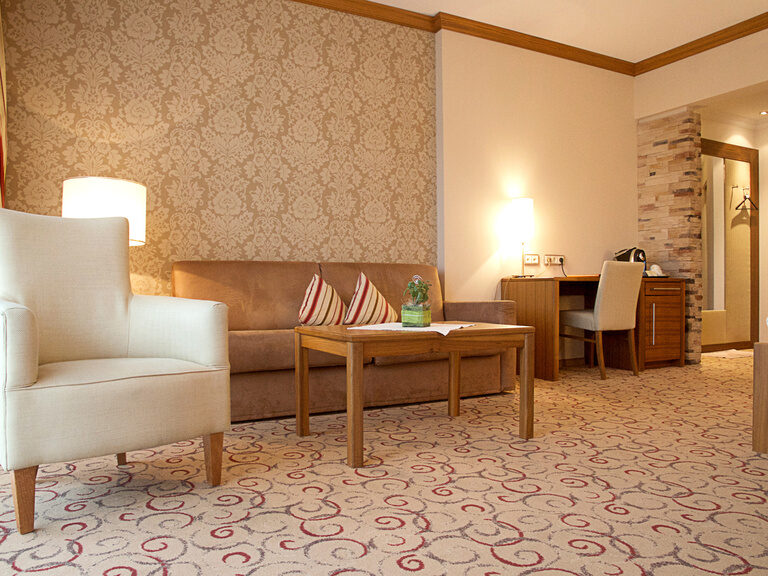 Modernes Wohnzimmer mit Couch und Kaffee-Tisch in der Mooshof-Gartensuite des Wellnesshotels Mooshof im Bayerischen Wald..