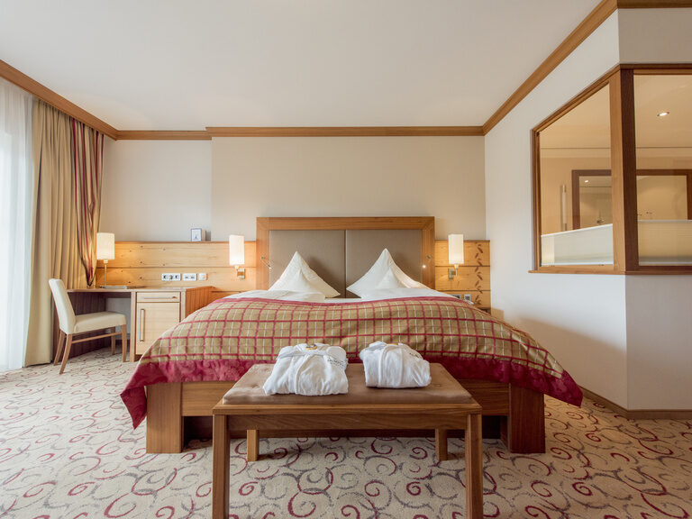 Großzügiges Zimmer mit gemütlichem Bett in der Gartensuite Schwalbennest des Wellnesshotels Mooshof im Bayerischen Wald.