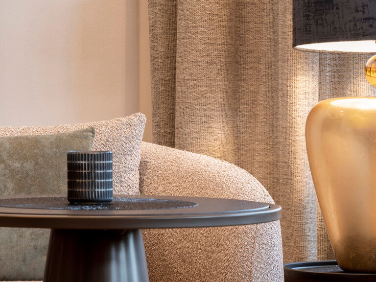 Ein Lampentisch mit silberner Oberfläche in der gemütlichen Hotellobby des Mooshofs.