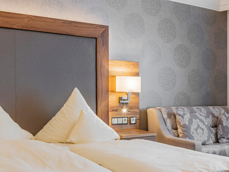 Ein stilvoll eingerichtetes Schlafzimmer mit einer Couch im Wellnesshotel Mooshof.