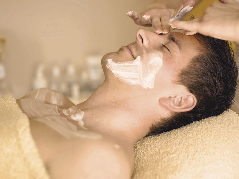 Ein Mann erhält eine entspannende Gesichtsbehandlung mit einer Maske in der Wellness-Oase des Hotels Mooshof im Bayerischen Wald.