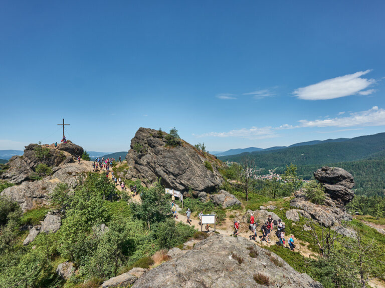 Eine Personengruppe genießt beim Wandern die Aussicht auf die felsige Landschaft.