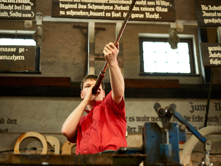 Ein Mann übt die beindruckende Kunst des Glasblasens aus.