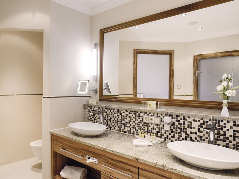 Das moderne Badezimmer mit zwei Waschbecken und großem Spiegel in der Honeymoonsuite des Hotels Mooshof im Bayerischen Wald.