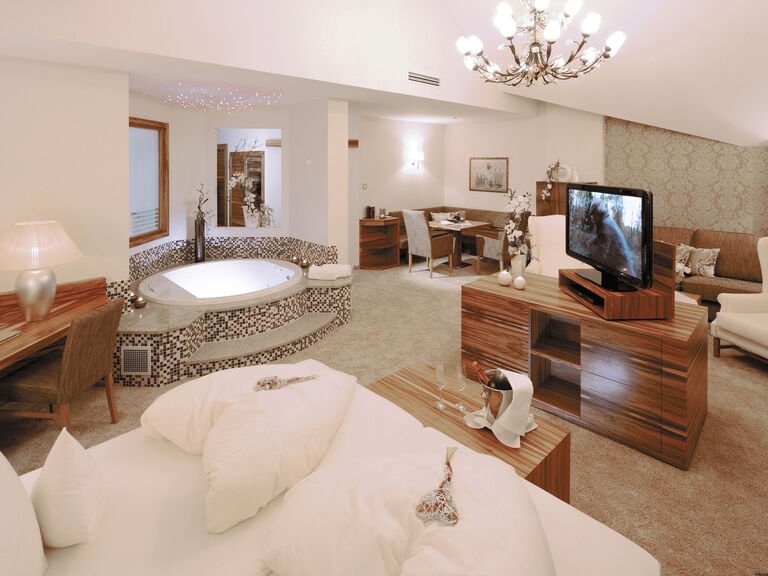Luxuriöse Inneneinrichtung mit frei im Raum stehenden Whirlpool im Zimmer der Honeymoonsuite des Wellnesshotels Mooshof im Bayerischen Wald.