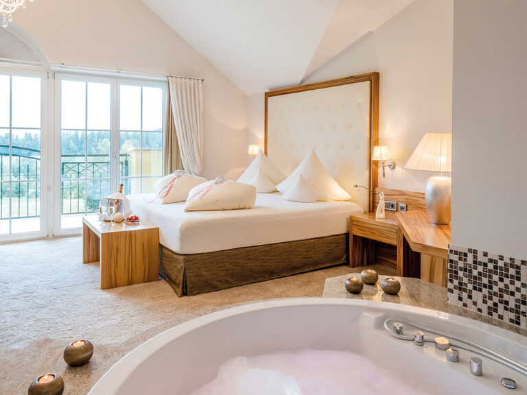 Der großzügige Raum der Honeymoon Suite mit sprudelndem Whirlpool und Bett versprechen Komfort pur im Wellnesshotel Mooshof.