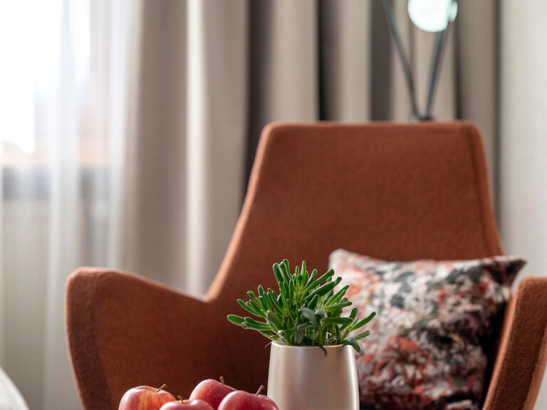 Gemütlicher Sitzbereich im Wellnesshotel Mooshof im Bayerischen Wald mit einem Tisch, auf dem Äpfel angeboten werden.