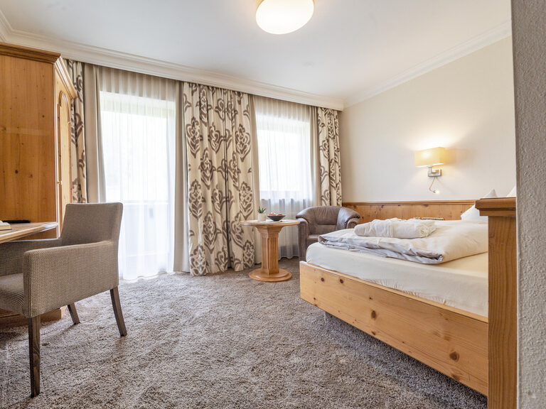 Das Schlafzimmer der Kategorie Typ 2 A im Hotel Mooshof im Bayerischen Wald mit Balkon und komfortablen Einzelbett.
