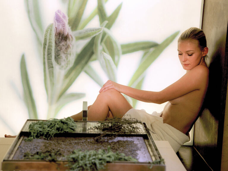 Im Wellnesshotel Mooshof im bayerischen Wald entspannt eine Frau in der Kräutersauna.