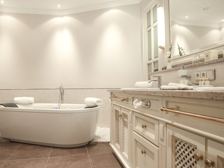 Die luxuriöse Badewanne und ein Waschbecken im geschmackvoll gestalteten Bad der Berkhain Suite Deluxe des Wellnesshotels Mooshof im Bayerischen Wald.