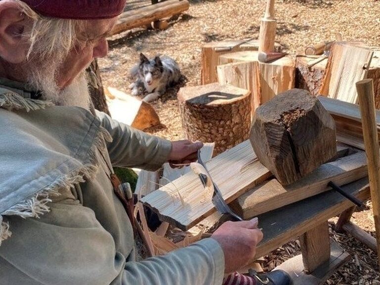 Eine Holzschnitzerei entsteht durch gezielte Handarbeit eines Mannes in Pullman City.