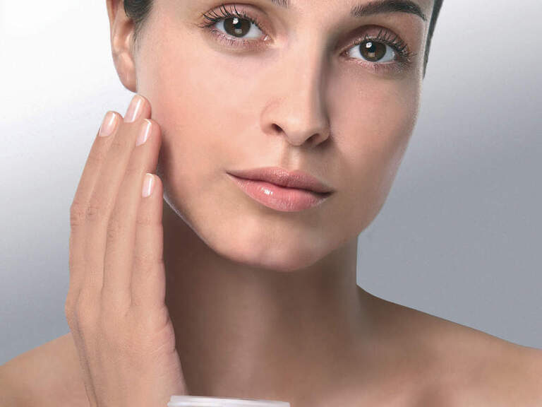 Eine Nahaufnahme zeigt eine Frau mit Hautpflegecreme der Marke Maria Galland.