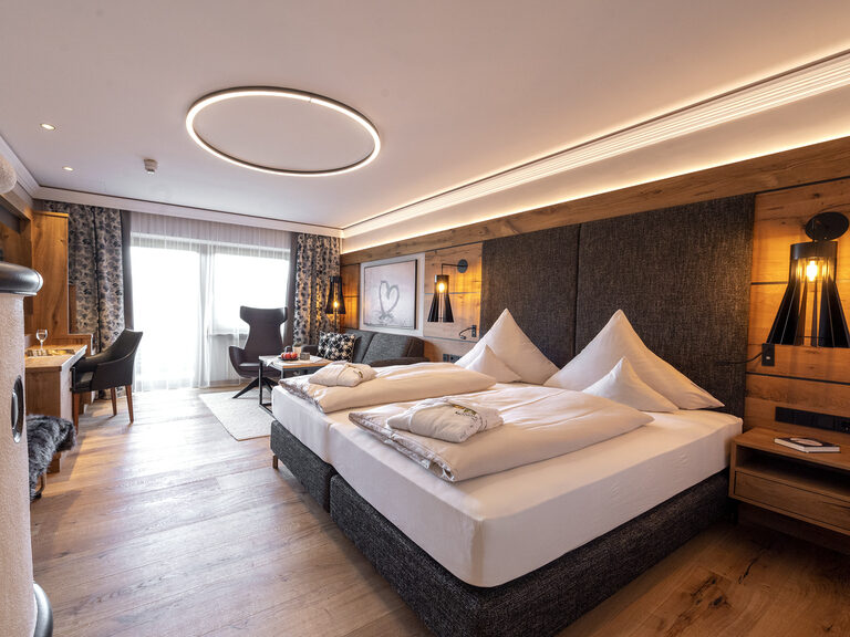Modernes Hotelzimmer im Wellnesshotel Mooshof im Bayerischen Wald mit Annehmlichkeiten wie einem Schreibtisch und Fernseher.