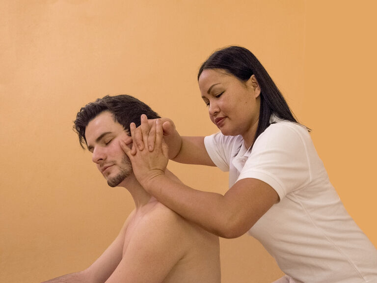 Ein Mann genießt eine helfende Behandlung gegen Verspannungen am Nacken im Wellnesshotel Mooshof im Bayerischen Wald.