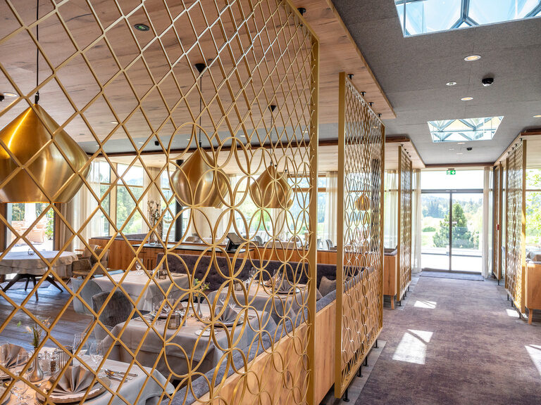 Stilvoll eingerichteter Speisesaal im neuen Restaurant des Wellnesshotels Mooshof, mit Aluminium- und Glasakzenten.