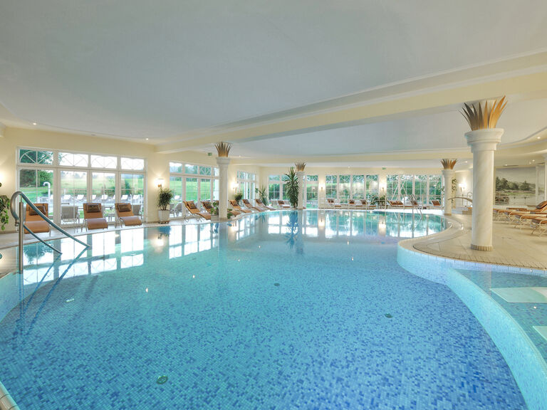 Das majestätische Panoramaschwimmbad mit zahlreichen gemütlichen Liegen am Beckenrand im erstklassigen Wellnesshotel Mooshof im Bayerischen Wald.