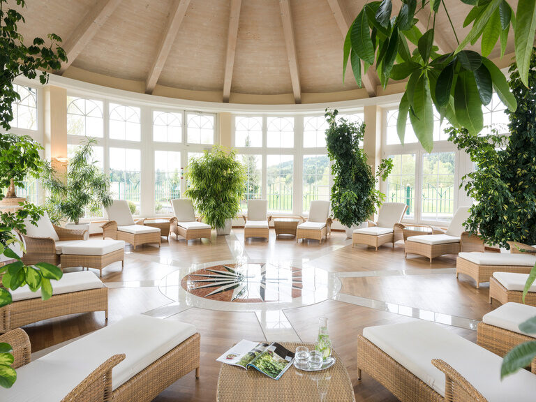 Relax Pavillion des Wellnesshotels Mooshof im Bayerischen Wald mit zahlreichen grünen Pflanzen und komfortablen Liegen zum Entspannen.
