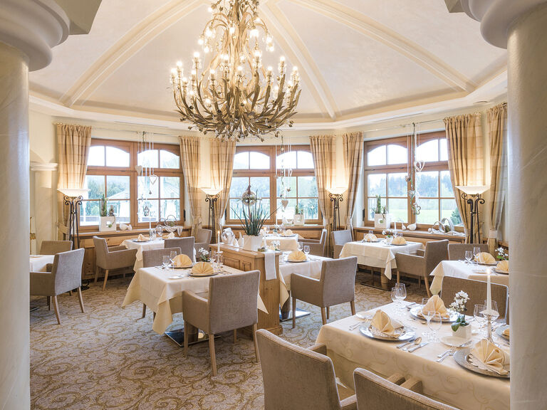 Speisesaal des eleganten Erkerlounge Restaurants unter einem prächtigen Kronleuchter im Hotel Mooshof im Bayerischen Wald.