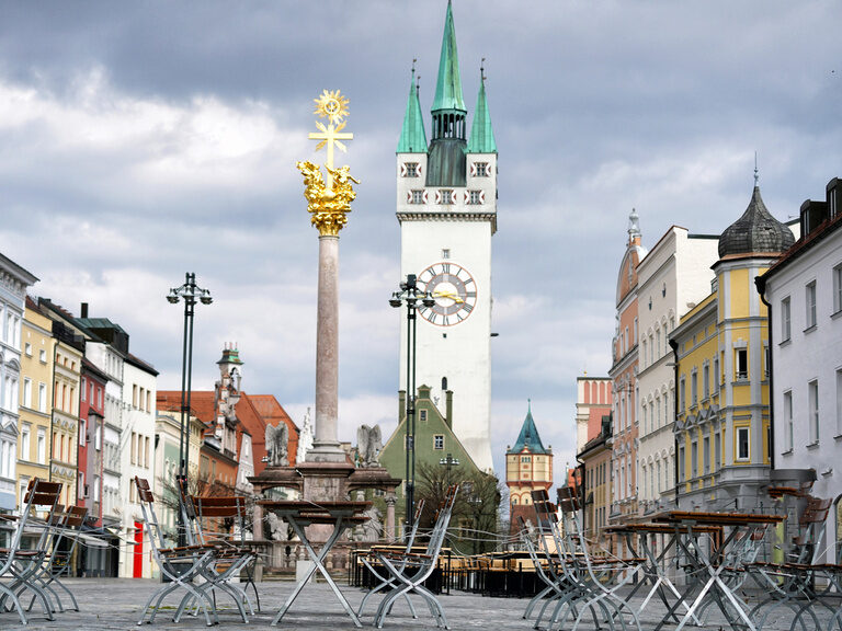 Der Außenbereich eines Restaurants auf dem Stadtplatz vor dem Rathausturm in Straubing.