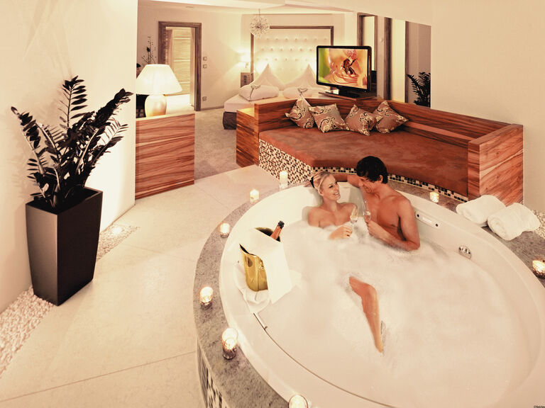 Ein Paar entspannt sich in der freistehenden schäumenden Badewanne der Romantiksuite Mooshof Himmel.
